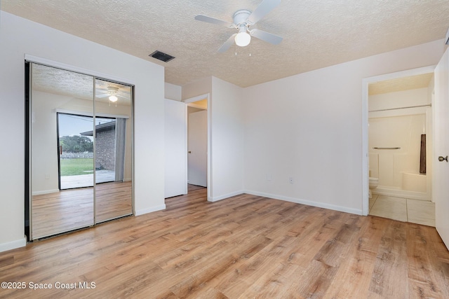 unfurnished bedroom featuring access to exterior, ceiling fan, ensuite bath, and light hardwood / wood-style floors