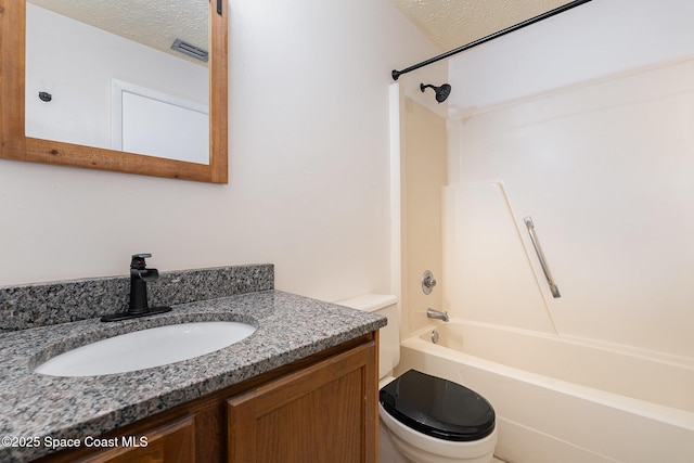 full bathroom featuring vanity, a textured ceiling, toilet, and tub / shower combination