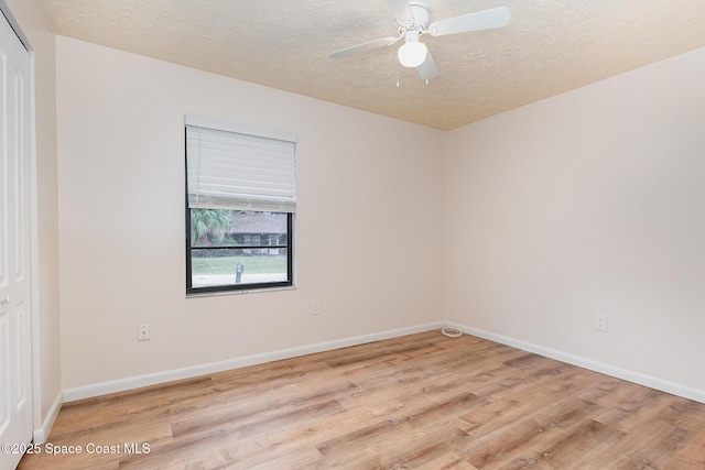 spare room with ceiling fan, a textured ceiling, and light wood-type flooring