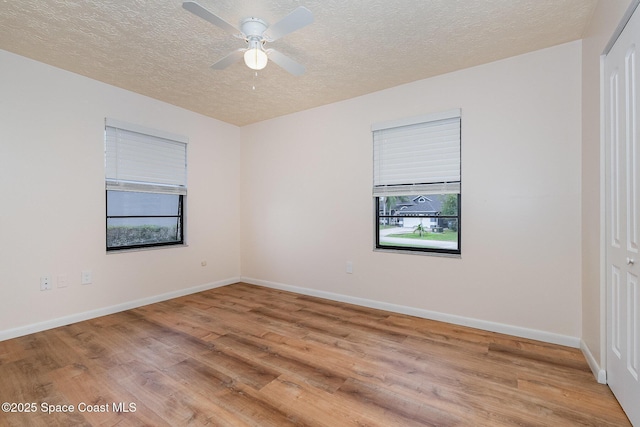 unfurnished room featuring a textured ceiling, light wood-type flooring, and ceiling fan