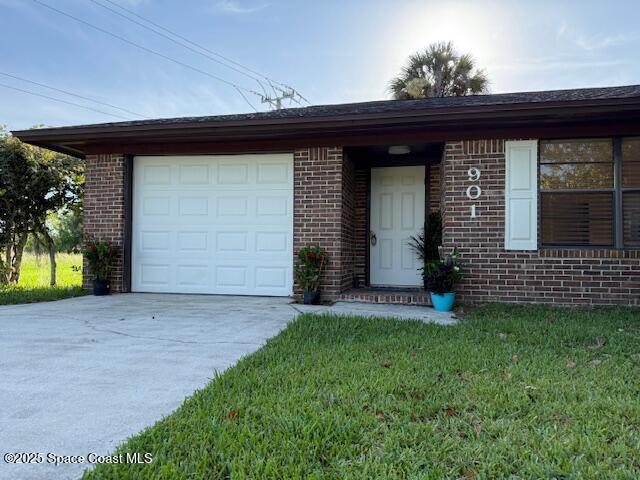 901 Emerson Dr NE, Palm Bay, FL 32907 - view of front of home featuring driveway, brick siding, a front yard, and a garage