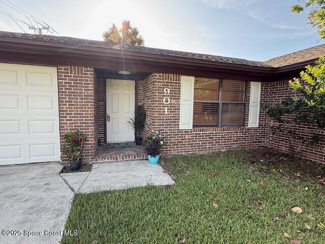 901 Emerson Dr NE, Palm Bay, FL 32907 - entrance to property with brick siding, a garage, and driveway