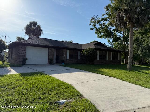 901 Emerson Dr NE, Palm Bay, FL 32907 - single story home featuring driveway, brick siding, an attached garage, and a front yard