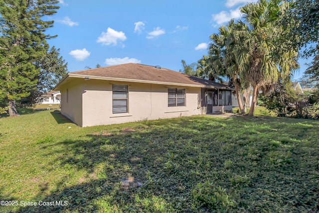 rear view of property featuring a lawn