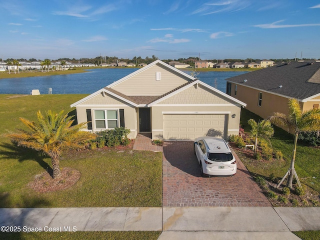 ranch-style house featuring a garage, a water view, and a front lawn