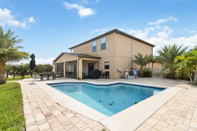 view of swimming pool with a sunroom, area for grilling, a patio area, and central air condition unit