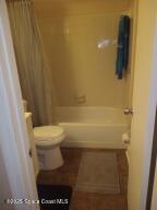 bathroom with shower / bath combination with curtain and toilet