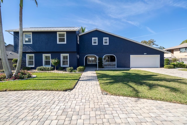 view of front of home featuring a porch, a garage, and a front lawn