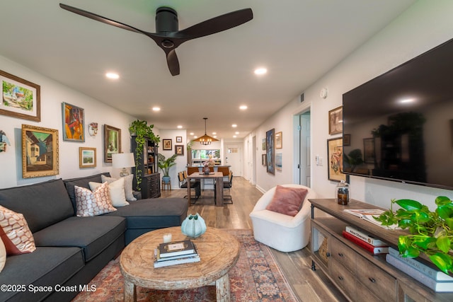 living room with hardwood / wood-style flooring and ceiling fan