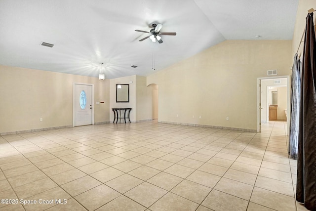 tiled empty room with ceiling fan and vaulted ceiling