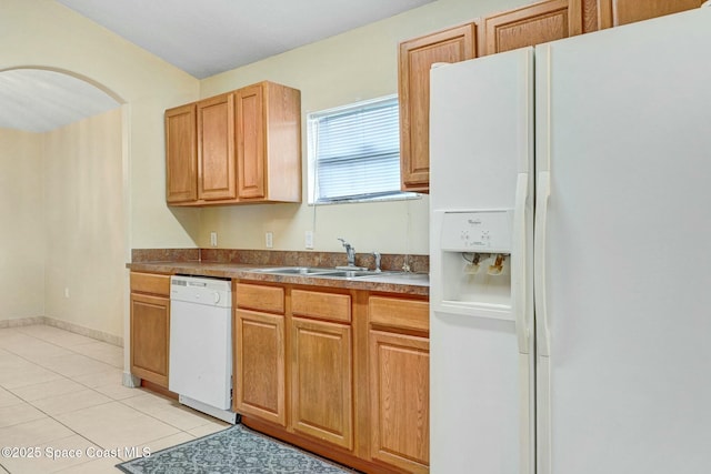 kitchen featuring sink, light tile patterned floors, and white appliances