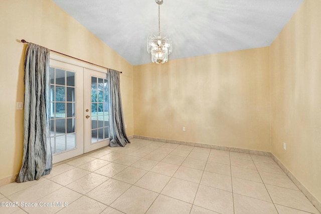 unfurnished room featuring a notable chandelier, lofted ceiling, light tile patterned floors, and french doors