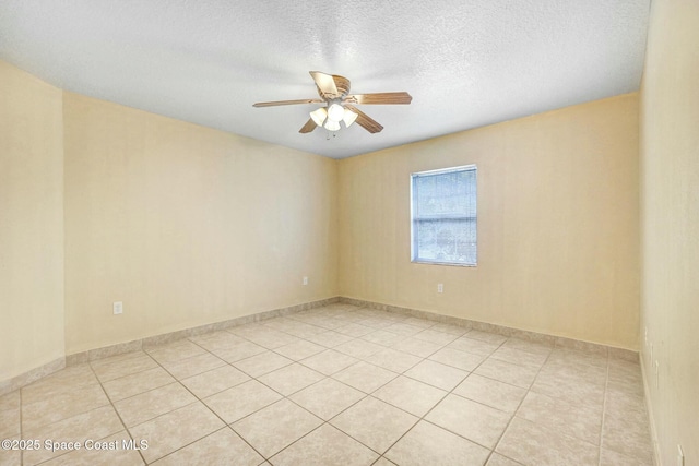 tiled spare room with a textured ceiling and ceiling fan