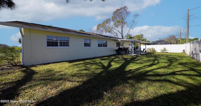 back of property with a lawn and a patio area