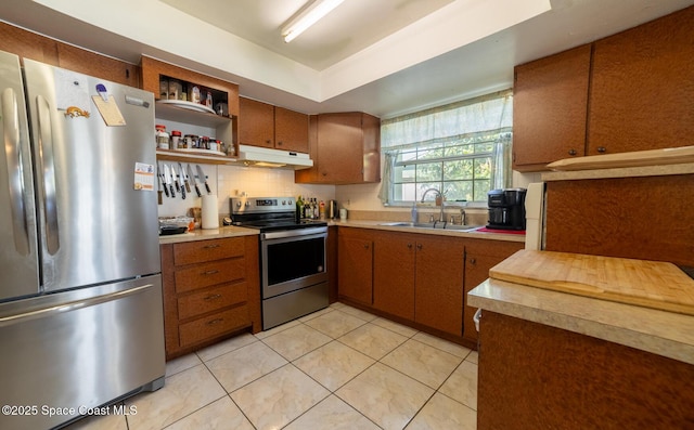 kitchen featuring decorative backsplash, light tile patterned floors, stainless steel appliances, and sink