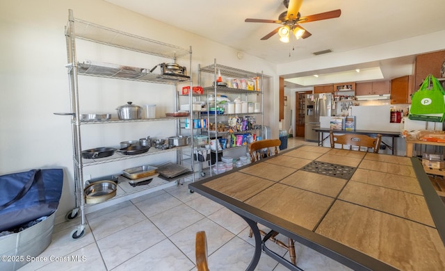 tiled dining room featuring ceiling fan