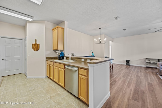 kitchen featuring sink, a textured ceiling, dishwasher, light brown cabinets, and hanging light fixtures