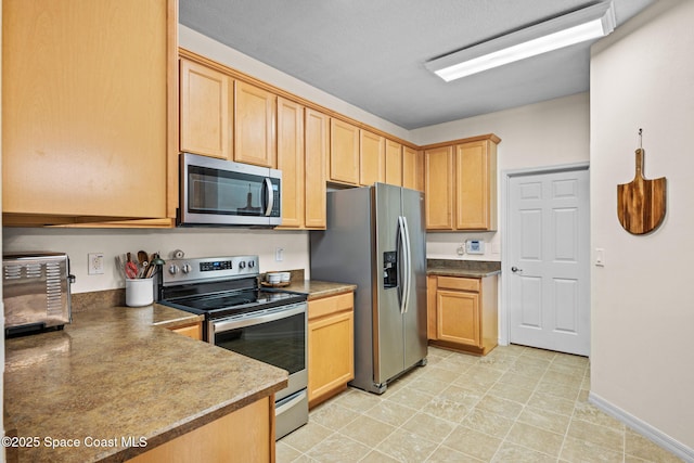 kitchen featuring stainless steel appliances and light brown cabinets