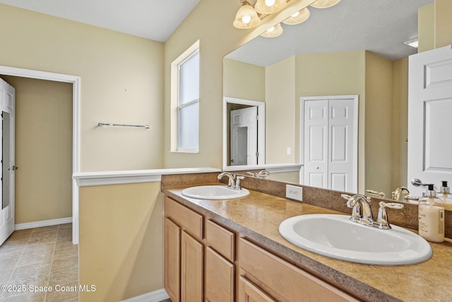 bathroom featuring tile patterned flooring, vanity, and a notable chandelier