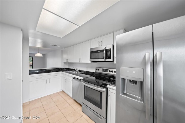 kitchen with hanging light fixtures, sink, light tile patterned floors, white cabinetry, and stainless steel appliances