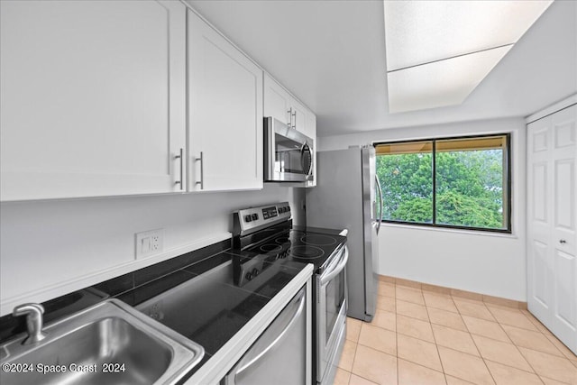 kitchen featuring white cabinets, light tile patterned flooring, sink, and appliances with stainless steel finishes