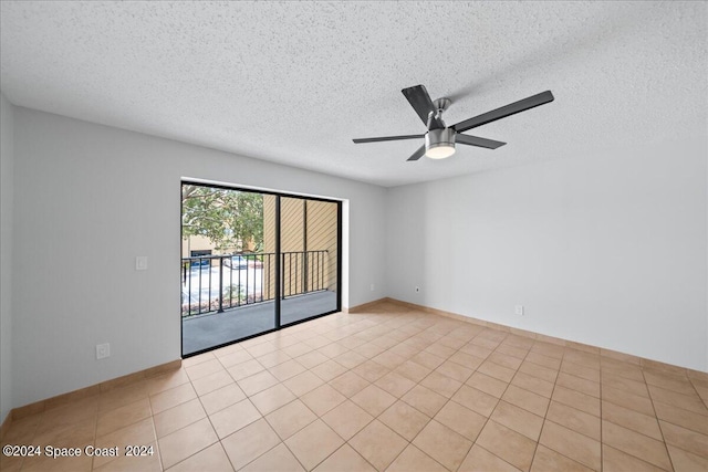 empty room featuring ceiling fan, light tile patterned flooring, and a textured ceiling