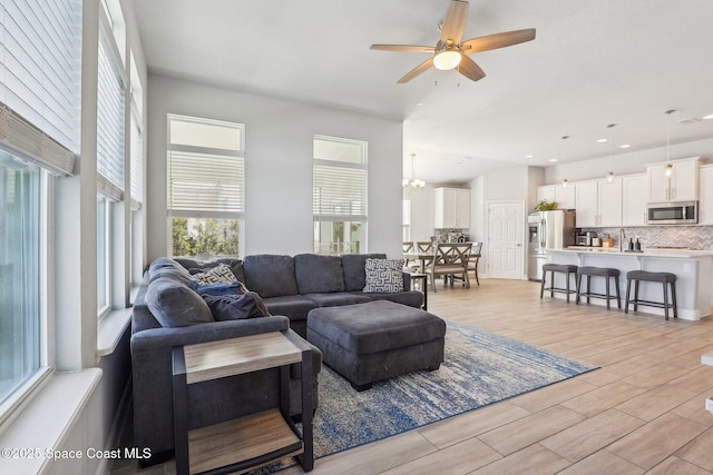 living room featuring ceiling fan with notable chandelier