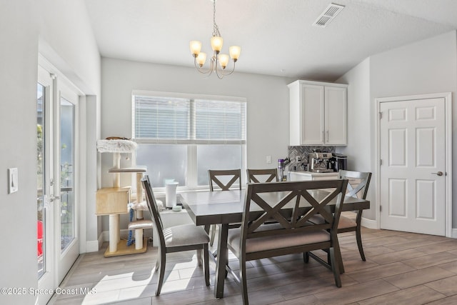 dining area featuring a textured ceiling and a notable chandelier