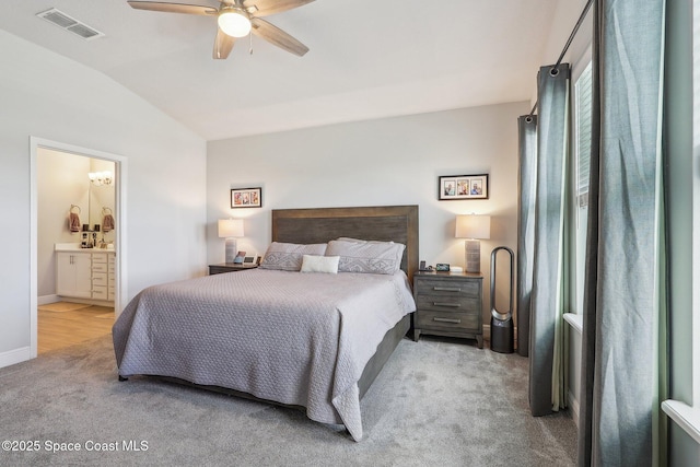 bedroom with connected bathroom, light colored carpet, ceiling fan, and lofted ceiling