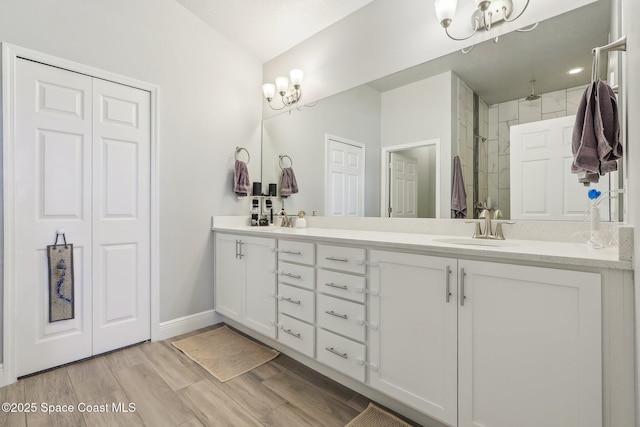 bathroom with a shower, vanity, and a chandelier