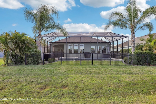 back of house with a lanai and a lawn