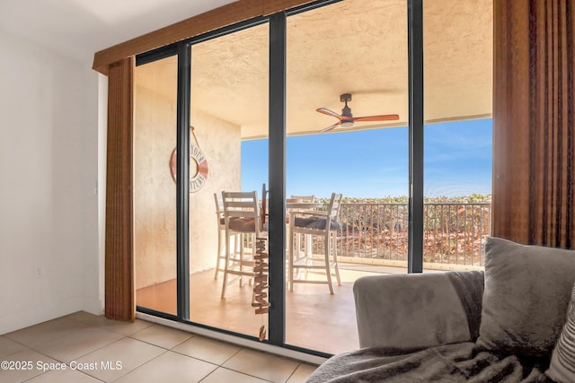 doorway with tile patterned flooring and ceiling fan