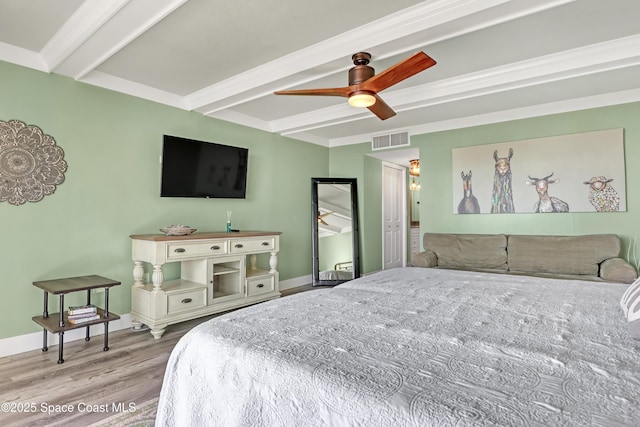 bedroom with beamed ceiling, light hardwood / wood-style flooring, and ceiling fan