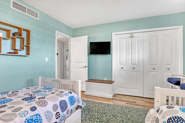 bedroom with wood-type flooring and a closet