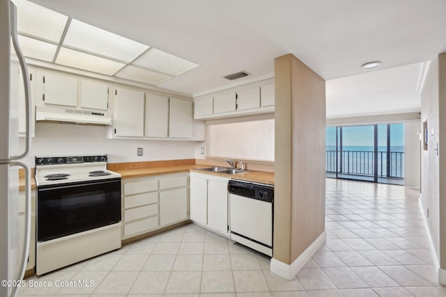 kitchen featuring sink, light tile patterned floors, and white appliances