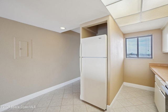 kitchen with white cabinets, electric panel, and white fridge