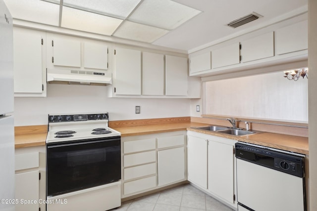 kitchen with white appliances, sink, light tile patterned floors, a notable chandelier, and white cabinets