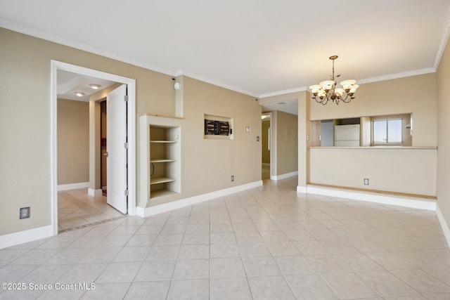 tiled spare room with a chandelier, built in features, and crown molding