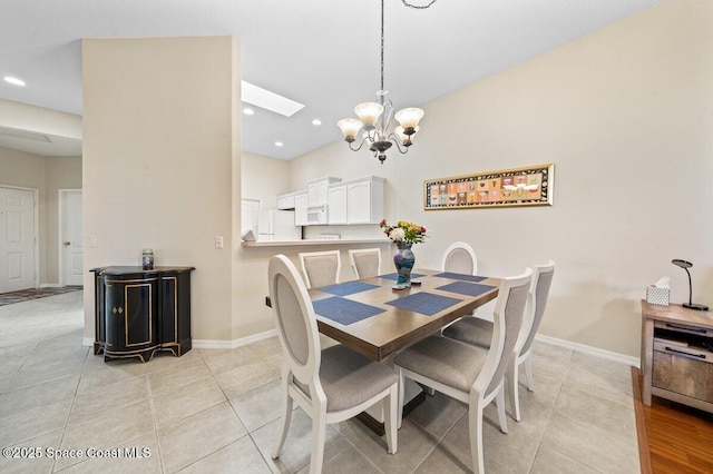 dining space with an inviting chandelier, light tile patterned floors, and a skylight