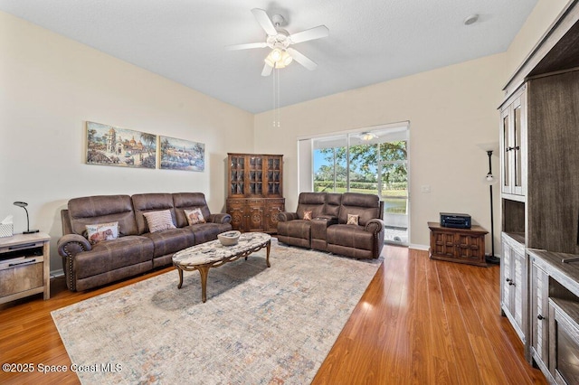 living room with light hardwood / wood-style flooring and ceiling fan