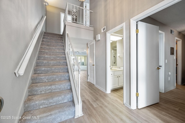 stairway featuring a wealth of natural light and wood-type flooring