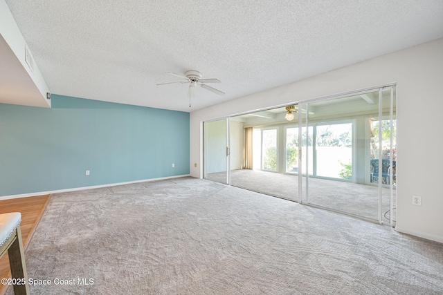 carpeted empty room with ceiling fan and a textured ceiling