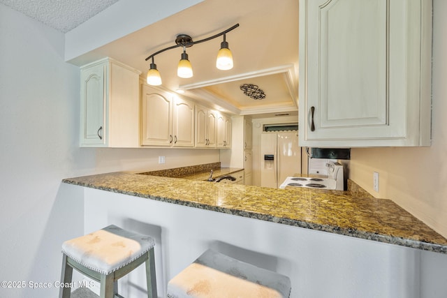 kitchen with white cabinets, dark stone counters, sink, and white appliances