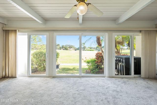 unfurnished sunroom featuring ceiling fan and beamed ceiling