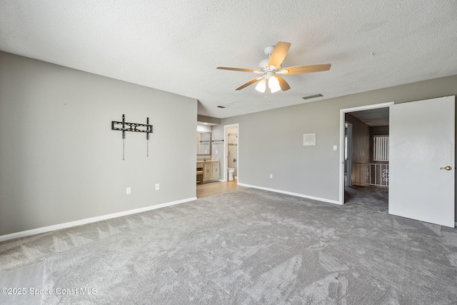 carpeted empty room featuring ceiling fan and a textured ceiling