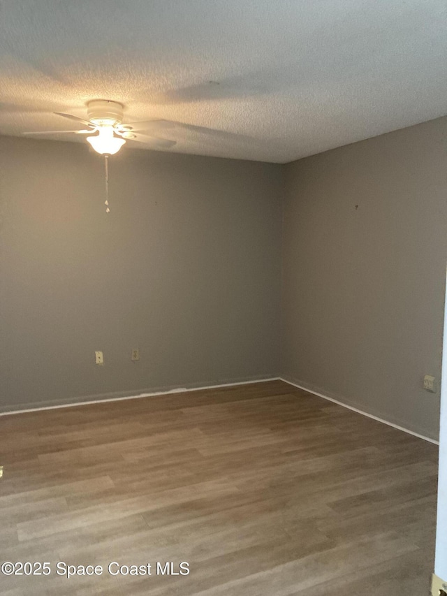 empty room with ceiling fan, hardwood / wood-style floors, and a textured ceiling