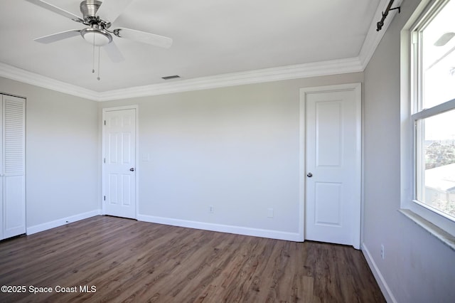 unfurnished bedroom featuring ceiling fan, ornamental molding, and dark wood-type flooring