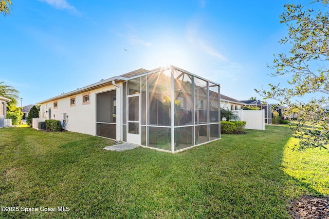 back of property with central AC unit and a lawn