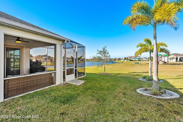 view of yard with a lanai and a water view