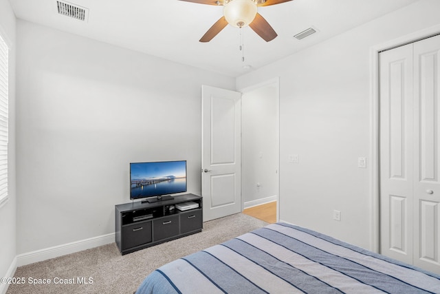 bedroom featuring ceiling fan, a closet, and light carpet